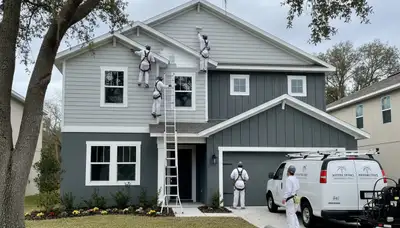 Professional house painters in Kissimmee FL applying fresh exterior home paint finish