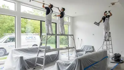 Technicians removing popcorn ceiling in Kissimmee FL home with clean dust-free painting service